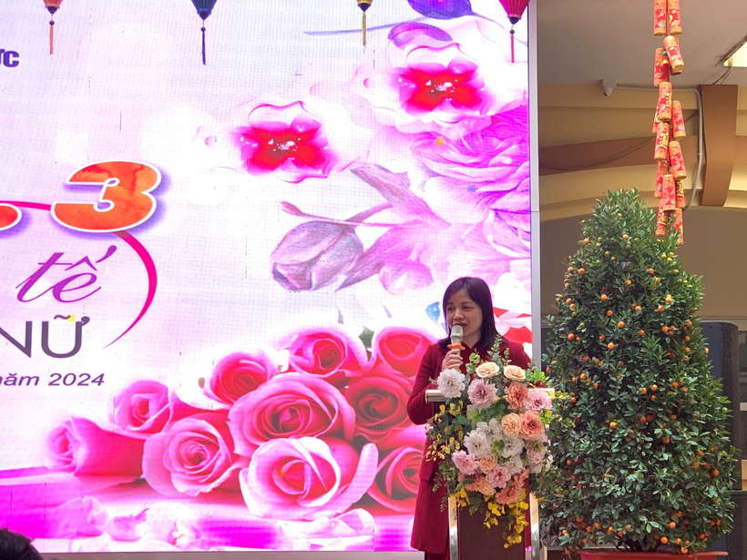 A person standing in front of a large screen with flowers

Description automatically generated