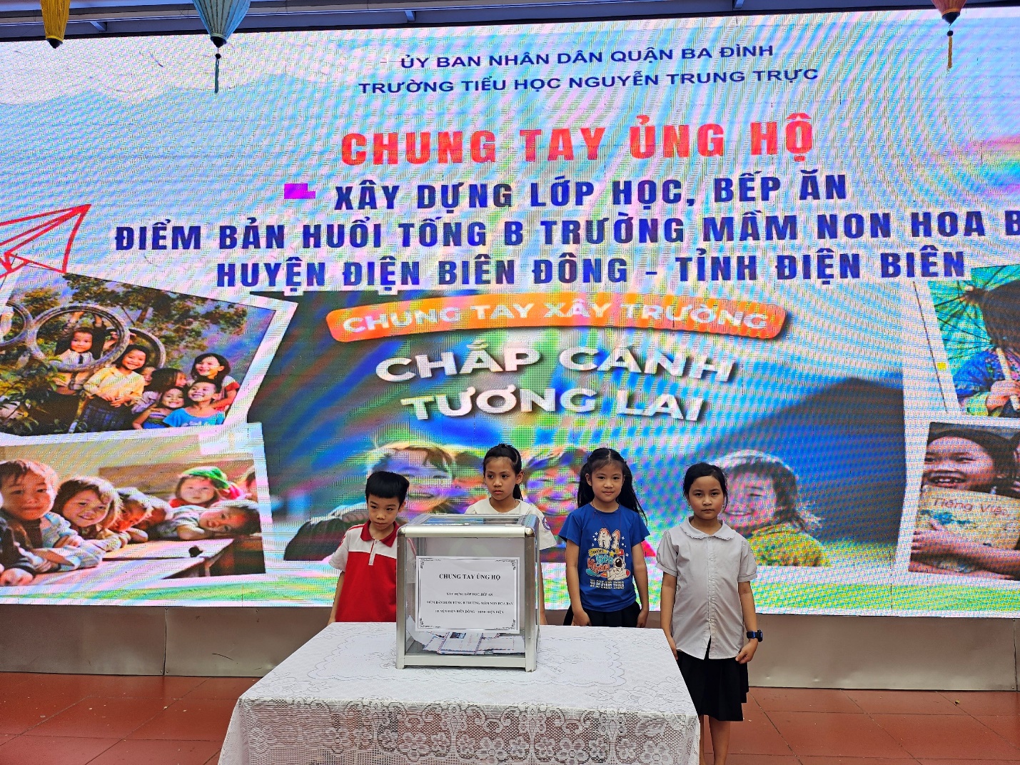 A group of children standing in front of a large screen

Description automatically generated